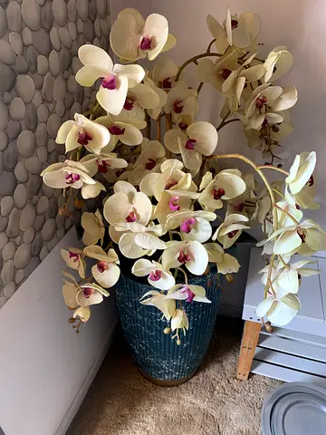 Large artificial orchid arrangement in decorative blue pot