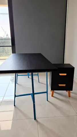 Black desk with blue metal legs and matching 2-drawer bedside cabinet