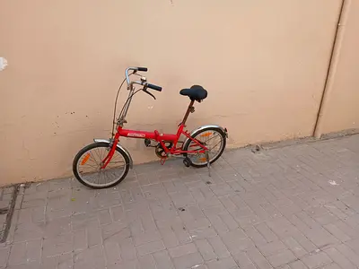 Red folding city bike - compact, single-speed, used for all ages