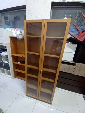 IKEA Billy-style tall bookcase with glass doors, light wood