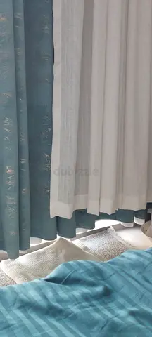 Layered white sheer and teal blackout curtains - set of panels