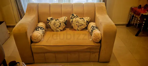 Two-seater beige upholstered sofa in good condition