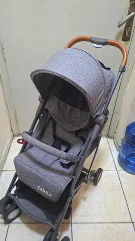 Lightweight grey Carro baby stroller with canopy and safety bar