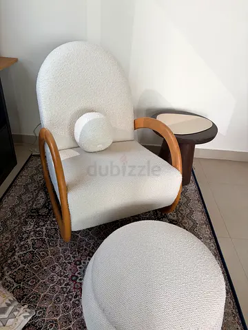 White boucle accent chair with wooden arms and matching ottoman