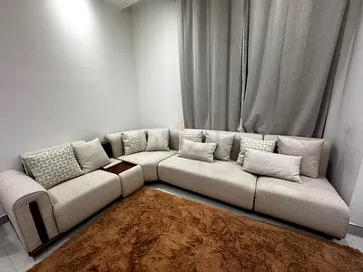 Light grey L-shaped modular sofa with corner storage armrest