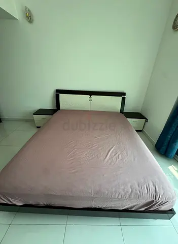 Wooden bed with storage in it alongside side tables set