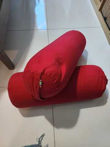 Pair of red cylindrical Yoga bolster cushions - good condition