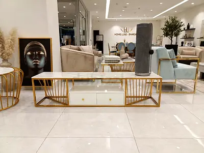 Long gold metal and glass TV console with white drawers
