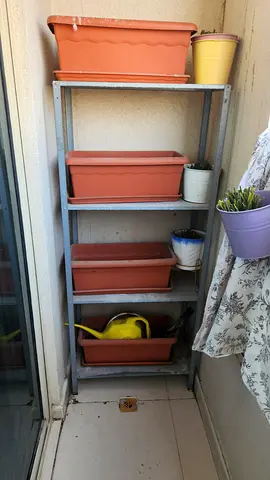 Metal shelving rack with terracotta planters (balcony storage)