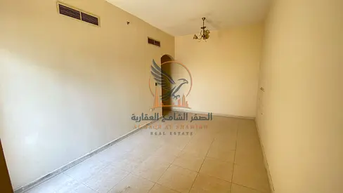 Spacious 1BR apartment for annual rent with central AC, balcony, free parking, prime location, close to services, and ready now