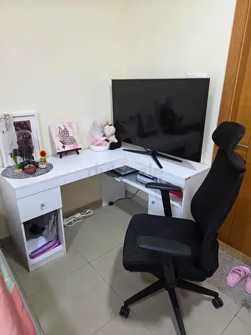 L-shaped white corner study desk with storage and black office chair
