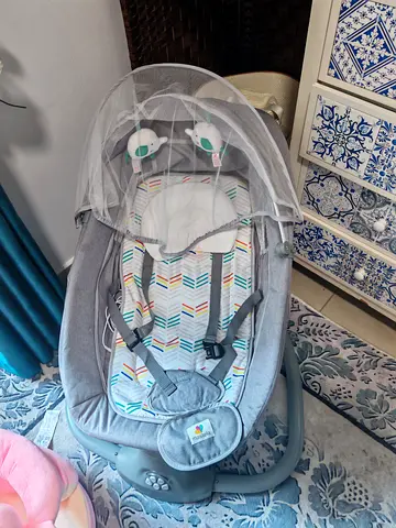 Baby bouncer rocker with toy bar and mosquito net - gently used