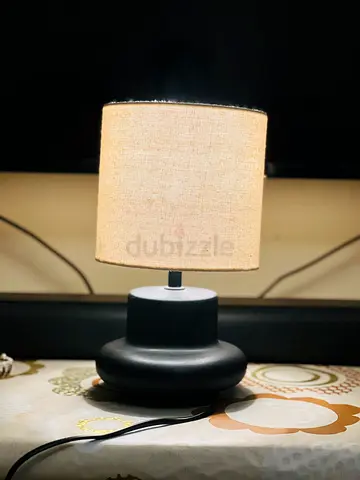 Small black ceramic table lamp with beige fabric shade