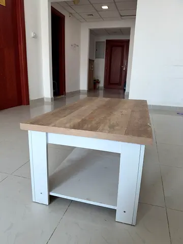 Simple wooden coffee table with white legs — good condition