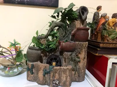 Decorative tabletop fountain with ceramic pots and greenery