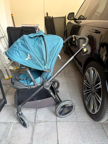 Well-used blue single stroller with canopy and storage basket