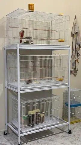 Three-tier bird cage stand with three large cages — white, on wheels and birds
