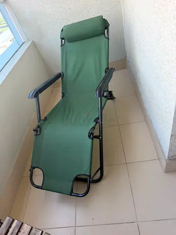Green reclining outdoor lounge chair with headrest
