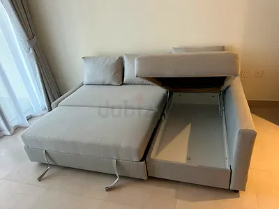 Light grey fabric L-shaped sofa bed with storage —