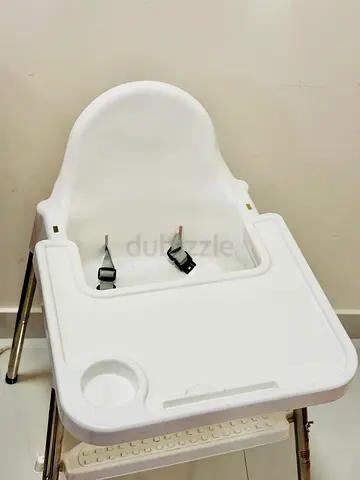 White baby high chair with detachable tray and safety straps