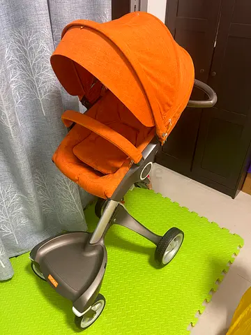 Stokky 3-wheel baby stroller/pram in orange — good condition