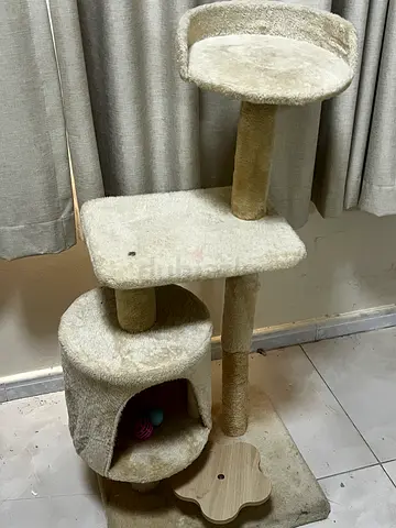 Beige multi-level cat tree with hammock bed and toys