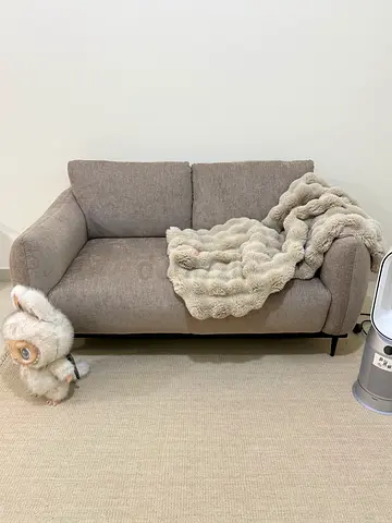 Two-seater beige fabric sofa in good condition