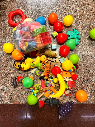 Mixed lot of small toys and play pieces — blocks, animals, fruit toys, balls
