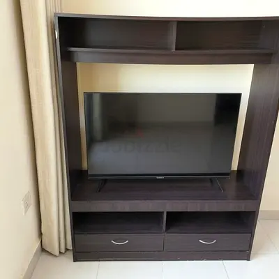 Dark wood TV entertainment unit with shelves and drawers