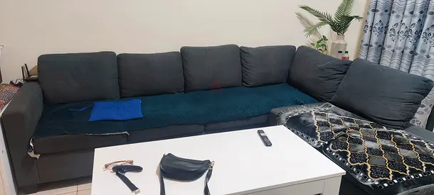 Large L-shaped dark grey fabric sofa – good condition, includes cushions