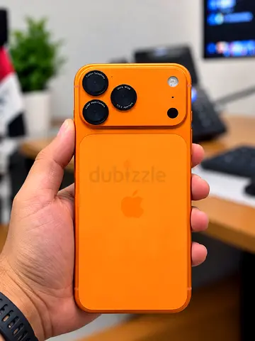 iPhone with orange silicone case and clip-on camera lenses