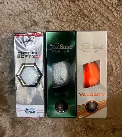 Box of mixed golf balls — Callaway Chrome Soft, Titleist AVX and Velocity