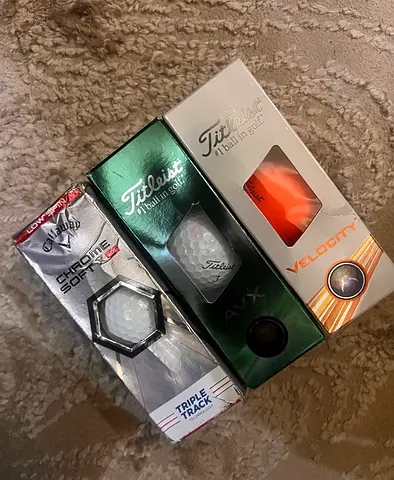 Box of mixed golf balls — Callaway Chrome Soft, Titleist AVX and Velocity
