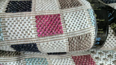 Used woven geometric area rug — beige with colored squares (good condition)