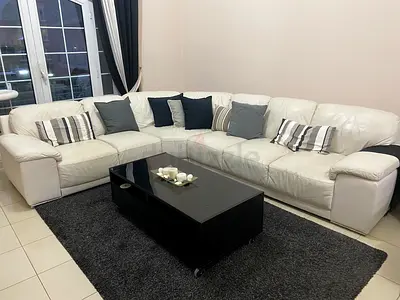 White leather L-shaped corner sofa with center table and TV console
