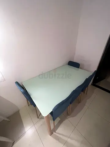 Modern white dining table with 4 blue upholstered chairs - good condition