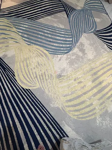Modern abstract area rug with blue and cream wave pattern