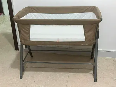 Side-sleeping bedside bassinet in beige - sturdy frame, mesh sides