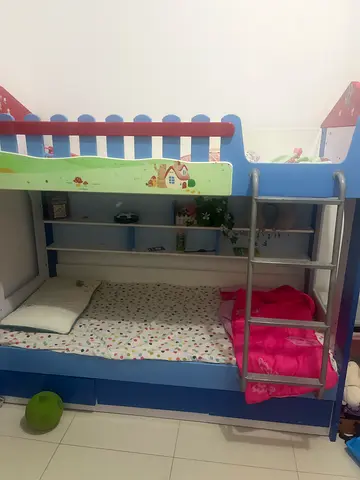 Blue wooden bunk bed with ladder and storage shelves - good condition