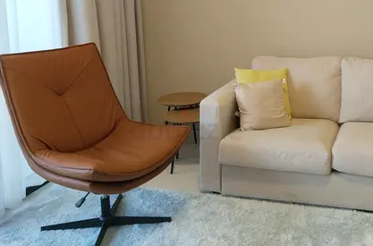 Brown leather swivel lounge chair with metal base