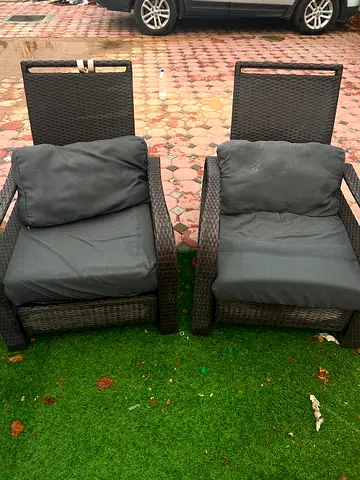 Pair of outdoor rattan reclining lounge chairs with cushions
