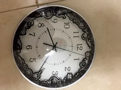 Round wall clock with decorative black-white frame - working