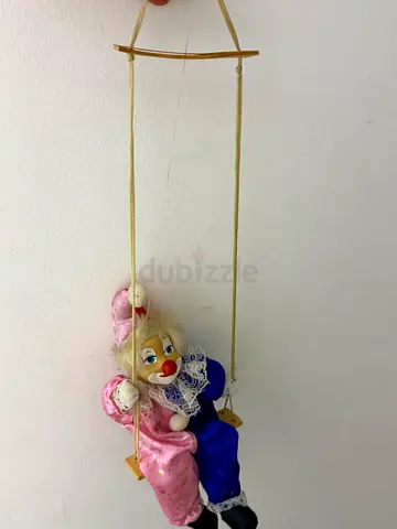Vintage clown marionette on wooden swing - decorative toy