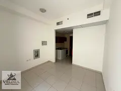 Studio for rent in Smart Tower, Al Amra area, Ajman. The unit features a separate kitchen, a balcony
