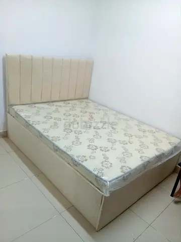 Queen bed with mattress and upholstered headboard - beige