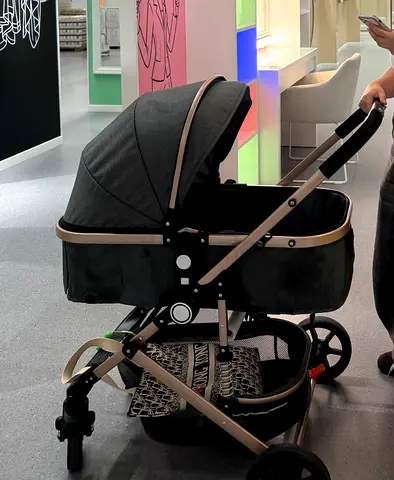 Compact bassinet-style baby stroller/pram - dark grey with gold frame