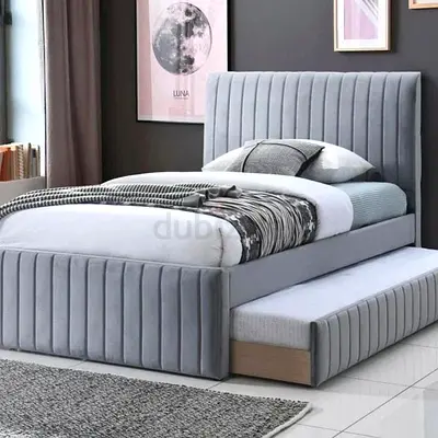 Grey upholstered single bed with pull-out trundle