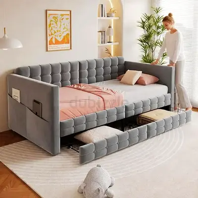 Grey upholstered daybed with pull-out trundle and storage pockets
