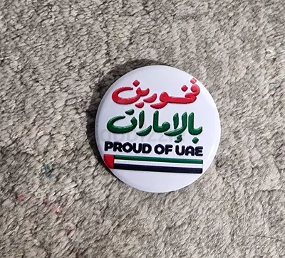 Round 'Proud of UAE' pin / badge with Arabic text