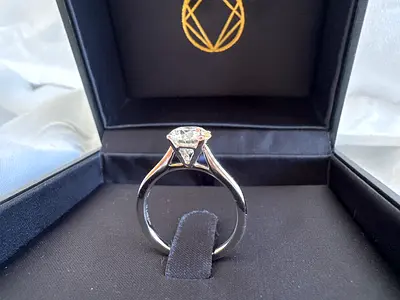 Solitaire-style silver ring with clear gemstone (in box)